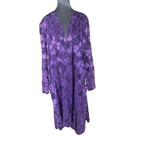 May include: A long purple robe with a floral pattern of leaves and grapes. The robe has a zipper down the front and pockets on the sides.