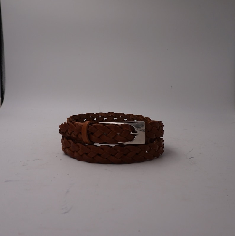 May include: A brown leather braided belt with a silver buckle.