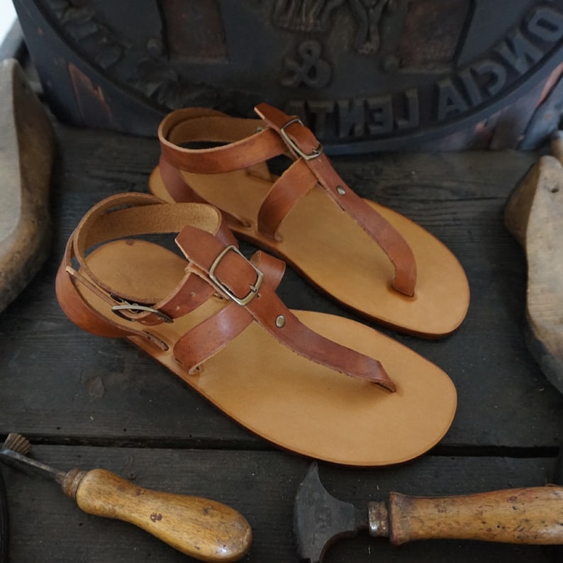 Pu&ograve; includere: Un paio di sandali in pelle marrone con fibbie e cinturini. Le sandali hanno un design semplice e sono realizzate in pelle di alta qualit&agrave;.