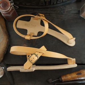 May include: A pair of tan leather sandals with a buckle fastening. The sandals are made by Mario Denis.