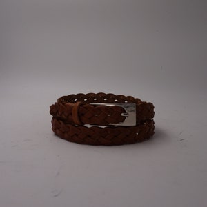 May include: A brown leather braided belt with a silver buckle.