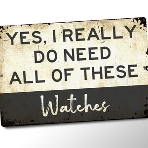 a sign with the text "YES, I REALLY DO NEED ALL OF THESE WATCHES" in a distressed, vintage-style font.