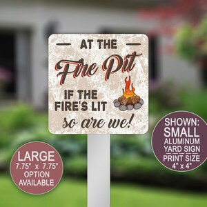 May include: A square aluminum yard sign with a distressed beige background. It features the text "AT THE Fire Pit IF THE FIRE'S LIT so are we!" in black and red, with a graphic of a campfire. Two circular labels indicate sizes of 4" x 4" and 7.75" x 7.75".