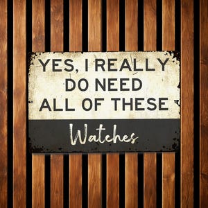 A sign with the text "YES, I REALLY DO NEED ALL OF THESE Watches" against a wooden background.