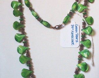 May include: A green and copper necklace with a tag that reads "Green Tears 34" Necklace. The necklace is made of green glass beads in the shape of teardrops and copper beads.