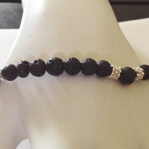 May include: A black lava rock beaded bracelet with silver spacer beads.