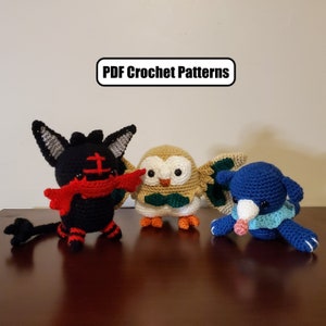 May include: Three crocheted stuffed toys: a black and red  Pokémon character, a beige and green owl, and a blue and white Pokémon character.  PDF Crochet Patterns.