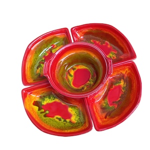 May include: A red and yellow ceramic serving dish with five sections. The center section is a bowl and the four outer sections are smaller bowls. The dish is decorated with a swirl pattern.