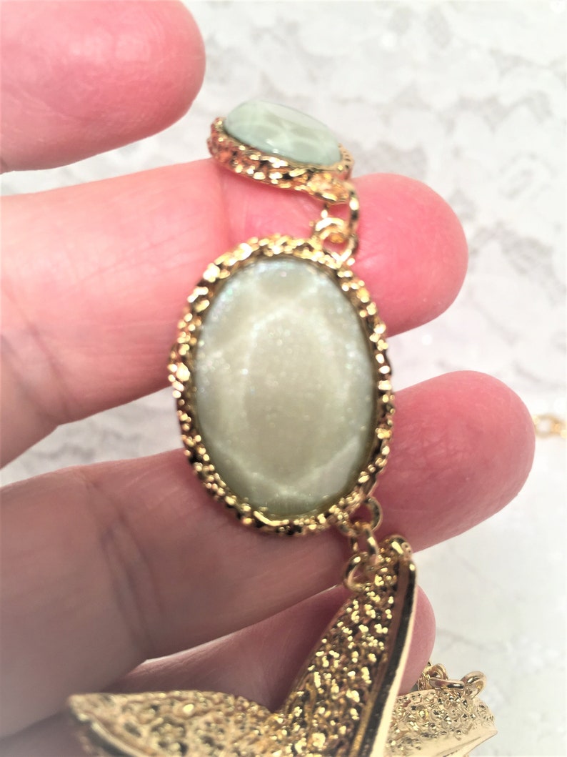 Good Condition. Chunky Chain Gold Tone Starfish Necklace with Lucite Light Green Sparkly Stones and Gold Tone Sand Dollar Medallions