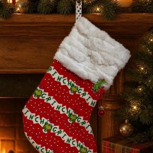 May include: A red Christmas stocking with a white faux fur cuff, featuring a repeating pattern of white polka dots, the green Grinch character, and the text "GRINCH" in green letters. A small green Grinch ornament hangs from the side of the cuff.