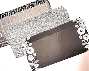 May include: Three black and white patterned envelopes with numbers 1 through 9 printed on the top envelope. The bottom envelope has a floral design.