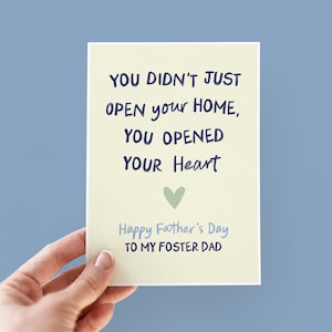 May include: A card with a light yellow background and blue text that reads "You didn't just open your home, you opened your heart."  A small green heart is below the text. The text "Happy Father's Day to my Foster Dad" is at the bottom of the card.