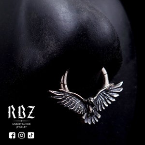 A highly detailed, Gothic crow / raven shaped clicker septum ring, made from solid Sterling silver, by RBZ Jewelry, displayed on a nose.