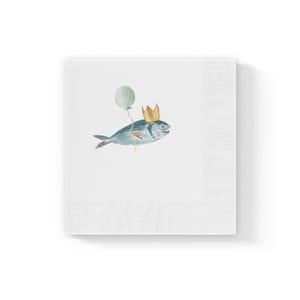May include: White square paper napkins with a watercolor illustration of a blue fish wearing a gold crown and holding a green balloon. The napkins have a ribbed border.
