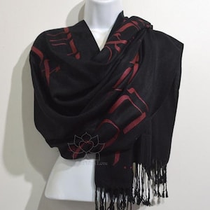 May include: Black shawl with red lettering. The lettering is in a cursive font and appears to be a quote or poem.