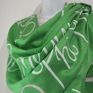 May include: Green scarf with white lettering that says "My Phi" on it.
