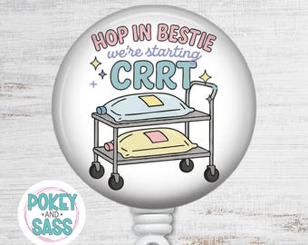 May include: A circular badge reel featuring a medical cart illustration with two fluid bags. The text reads "HOP IN BESTIE we're starting CRRT" in pink, purple, and blue. Small star icons surround the cart, and a small logo reads "POKEY AND SASS".