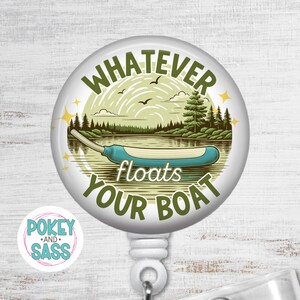 May include: A white retractable badge reel with a nature scene and the text "WHATEVER floats YOUR BOAT". The design features a lake, trees, birds, and a blue canoe. The reel has a white clip and a small logo.