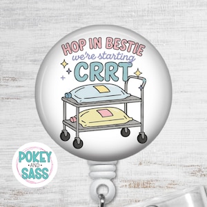 May include: A white badge reel with a cartoon illustration. The design features a hospital cart with pillows and the text "HOP IN BESTIE we're starting CRRT". The reel also has the text "POKEY AND SASS".