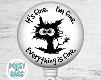 May include: A circular white badge reel featuring a black, messy-haired cat illustration with large, wide-eyed blue pupils and red veins. The text reads, It's fine. I'm fine. Everything is fine. The badge reel has a white plastic base and clip.