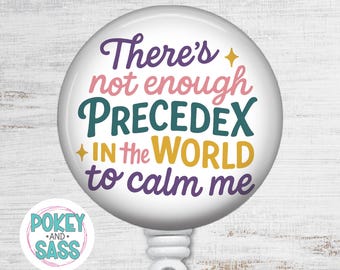 May include: A round white badge reel featuring the purple, pink, teal, and yellow text: There's not enough PRECEDEX in the world to calm me, accented with two small yellow stars. A small circular logo with the text POKEY AND SASS is visible.