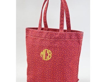 May include: A pink canvas tote bag with a geometric pattern and a gold monogram "MCB" on the front.