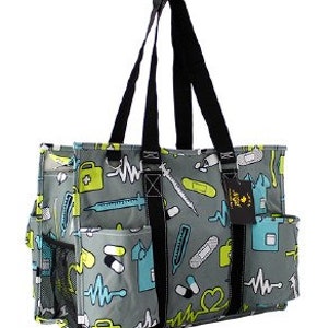 Può includere: Una borsa tote grigia con una stampa a tema medico colorata. La stampa include cuori, pillole, bende, stetoscopi e linee ECG. La borsa ha più tasche e una chiusura con cerniera.