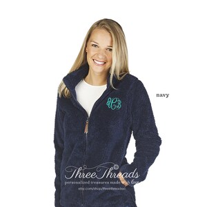 May include: A navy blue fleece jacket with a zip fastening and a monogrammed "HCB" on the chest. The jacket has a soft, fuzzy texture and is ideal for keeping warm in the colder months. Three Threads personalised treasures made with love. etsy.com/shop/threethreadsdsc