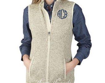 May include: A beige fleece vest with a white zip and two pockets. The vest has a navy blue monogram "ACB" on the front.