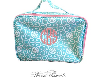 May include: A turquoise and white patterned zippered pouch with a pink zipper and a pink monogrammed "CBS" on the front.  The pouch has a pink handle.