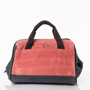 May include: A red and gray canvas tote bag with two brown handles and a zipper closure. The bag has a monogrammed patch with the initials "R|S" on the front.