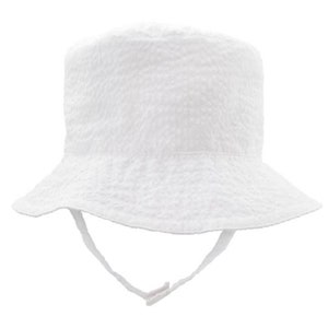 May include: A white bucket hat with a chin strap.
