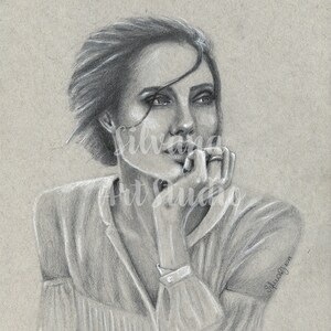 Puede incluir: Retrato a l&aacute;piz de una mujer con pelo corto, vestida con una blusa de color claro. La obra est&aacute; firmada "Silvana Art Studio 2019". La mujer apoya la barbilla en la mano, con una expresi&oacute;n pensativa.