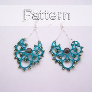 May include: Teal and green beaded earrings with a dark gray bead in the center of each earring. The earrings are hanging from silver hooks.