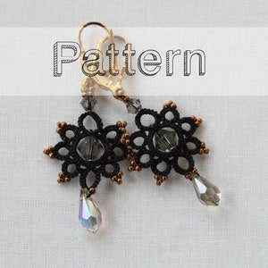 May include: A pair of black and gold earrings with a delicate snowflake design and a crystal drop. The earrings are labeled "Pattern".