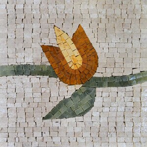 Op de afbeelding: Een mozaïektegel met een gestileerde oranje tulp met groene bladeren. De tegel is gemaakt van kleine, onregelmatige stukjes steen.