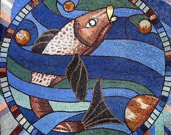 May include: A mosaic artwork featuring a fish swimming in blue and green water. The fish has a brown body, white scales, and a dark tail fin. The artwork is circular, with a border of white and brown tiles.