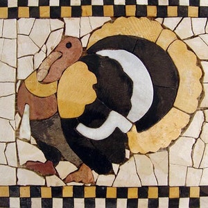Op de afbeelding: Een mozaïekkunstwerk dat een kalkoen voorstelt met een zwart, wit en bruin lichaam en een gele en bruine kop en nek. De kalkoen is omringd door een geruite rand van zwarte, witte en gele tegels.
