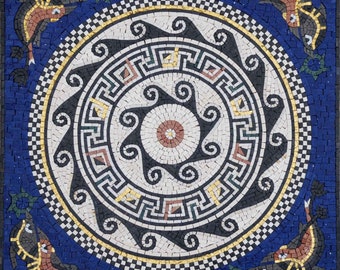 May include: A blue and white mosaic tile with a circular design featuring a black and white geometric pattern. The center of the circle has a star-shaped design with a red and white center. The tile is surrounded by a border of black and white squares.