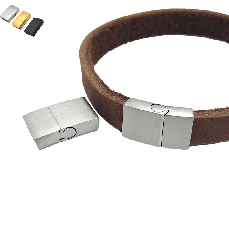 May include: A silver magnetic clasp for a leather bracelet. The clasp is made of two rectangular pieces that fit together.