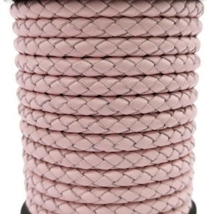 May include: A spool of light pink braided leather cord. The cord is tightly woven, creating a textured surface. The color is a soft, muted pink, and the cord appears to be new and unused. This cord is suitable for jewelry making and other crafts.