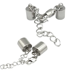 May include: Two silver metal end caps with a silver chain and clasp. The end caps are cylindrical and have a smooth finish.