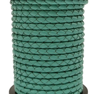 May include: A roll of teal braided leather cord. The cord is tightly wound and has a smooth, polished finish.