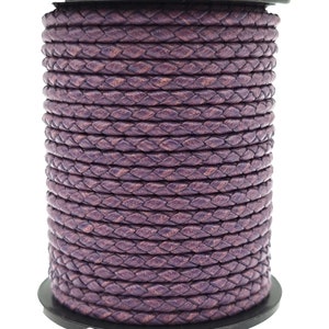 May include: A spool of purple braided leather cord. The cord is approximately 5mm wide and is perfect for crafting projects.