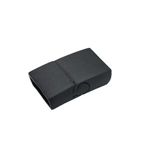 May include: Black plastic magnetic clasp for a bracelet or necklace. The clasp is rectangular and has a smooth, matte finish.