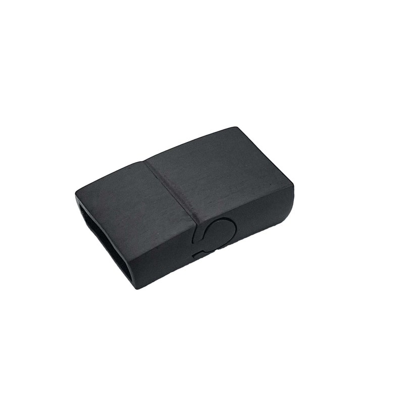 May include: Black plastic magnetic clasp for a bracelet or necklace. The clasp is rectangular and has a smooth, matte finish.