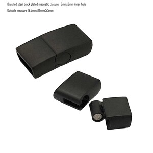 May include: Black magnetic clasp for jewelry or crafts. The clasp is made of brushed steel and has a rectangular shape. It measures 19.5mm x 10mm x 5.5mm and has an 8mm x 3mm inner hole.