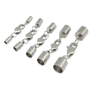 Op de afbeelding: Een set van vijf zilverkleurige sieradensluitingen, gerangschikt op grootte in een rij. Elke sluiting bestaat uit een cilindrische eindkap, een ringetje en een karabijnsluiting. De metalen onderdelen hebben een gladde en gepolijste afwerking.