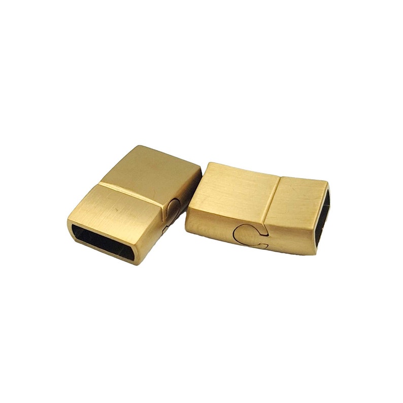 May include: Two gold-toned magnetic clasps for jewelry making. The clasps are rectangular and have a brushed finish.