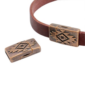 May include: Two antique copper-toned magnetic clasps with a geometric design. The clasps are designed to be used on leather bracelets or necklaces.